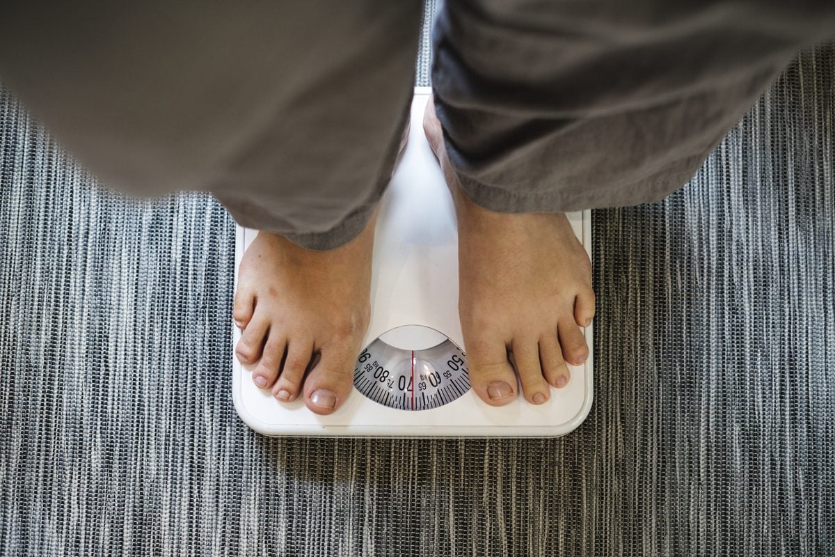Keto Plateau: Ursachen und was beim Durchbrechen hilft 1 Nackte Füße auf einer analogen Personenwaage